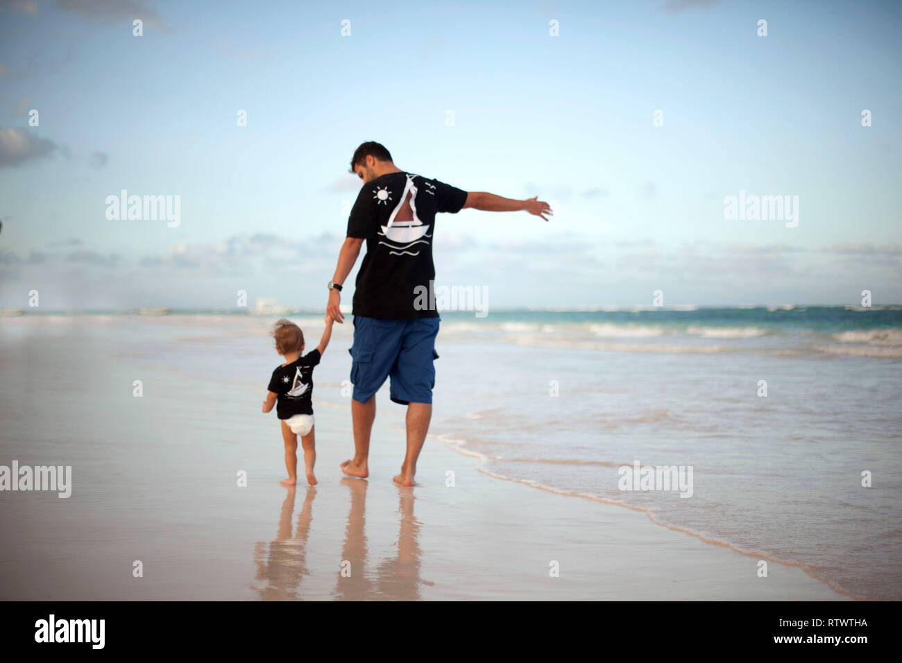 Father and Daughter Playing Together at the Beach at Sunset Stock Photo