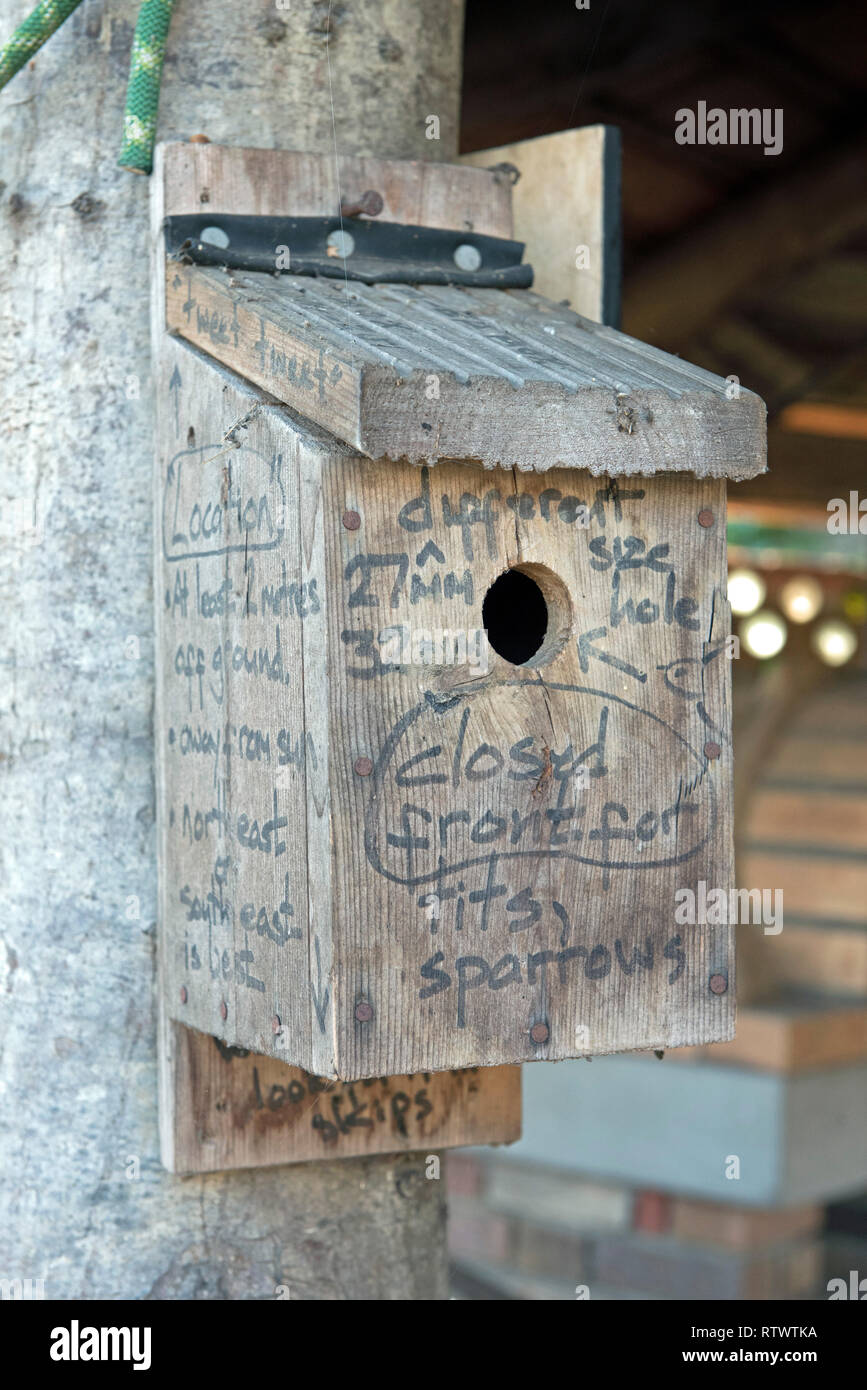 Wooden nestbox with advice for it's location and which species of birds are likely to use that type of box it written onto it. Stock Photo