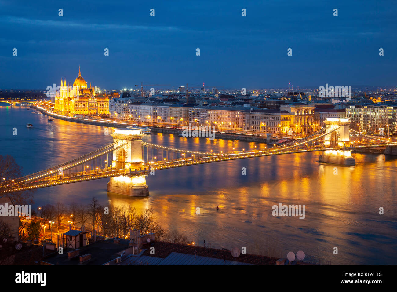 Night falls on the Danube in Budapest, Chain Bridge and Hungarian Parliament in the distance. Stock Photo