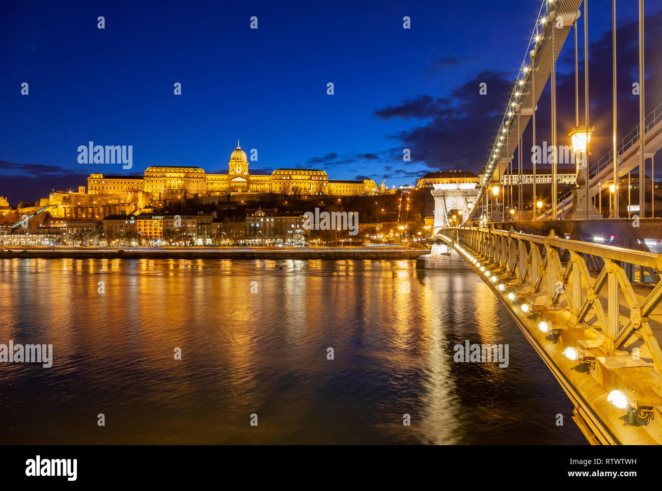 Night falls on the Danube in Budapest, Buda Castle in the distance. Stock Photo