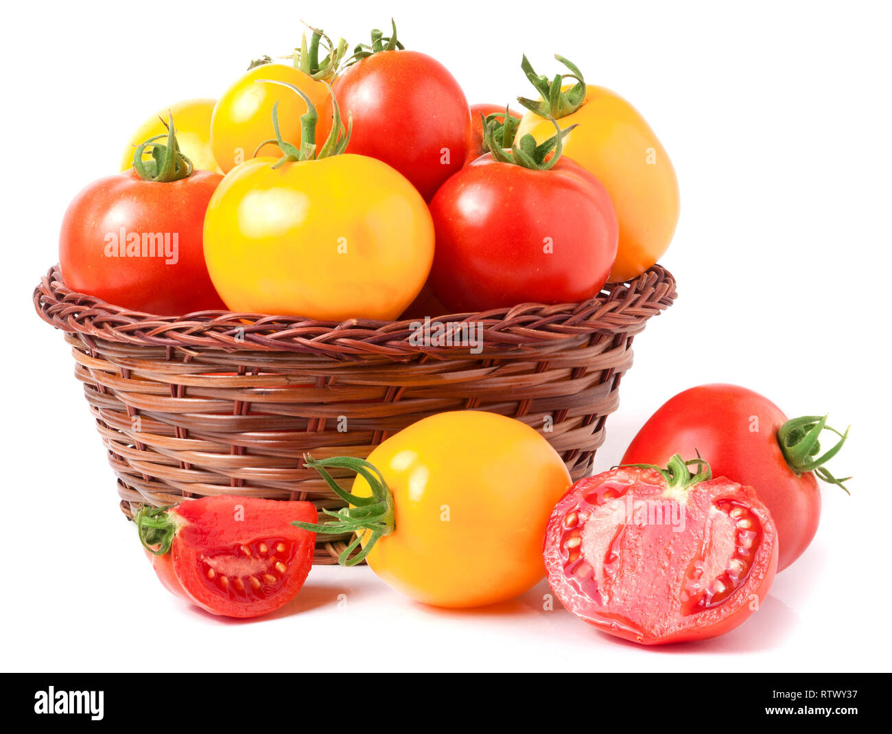red and yellow tomatoes in a wicker basket isolated on white background ...