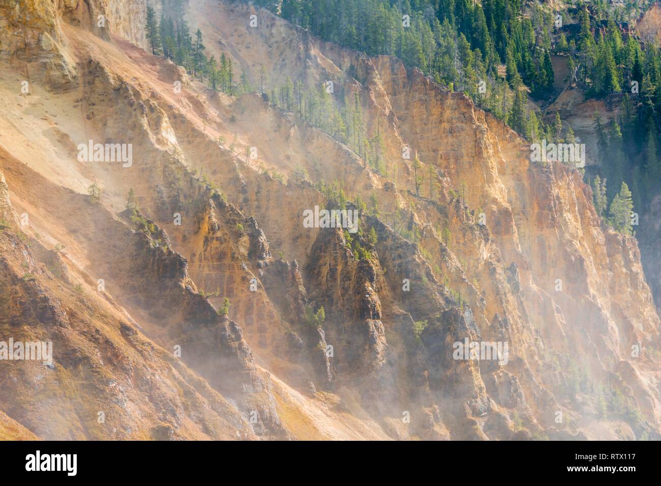 Rugged rock face of the Grand Canyon of the Yellowstone with water vapor of the waterfall, view from North Rim Stock Photo