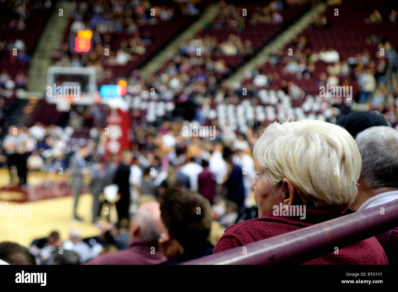 Older fan watching an NCAA basketball game at Texas A&M University in