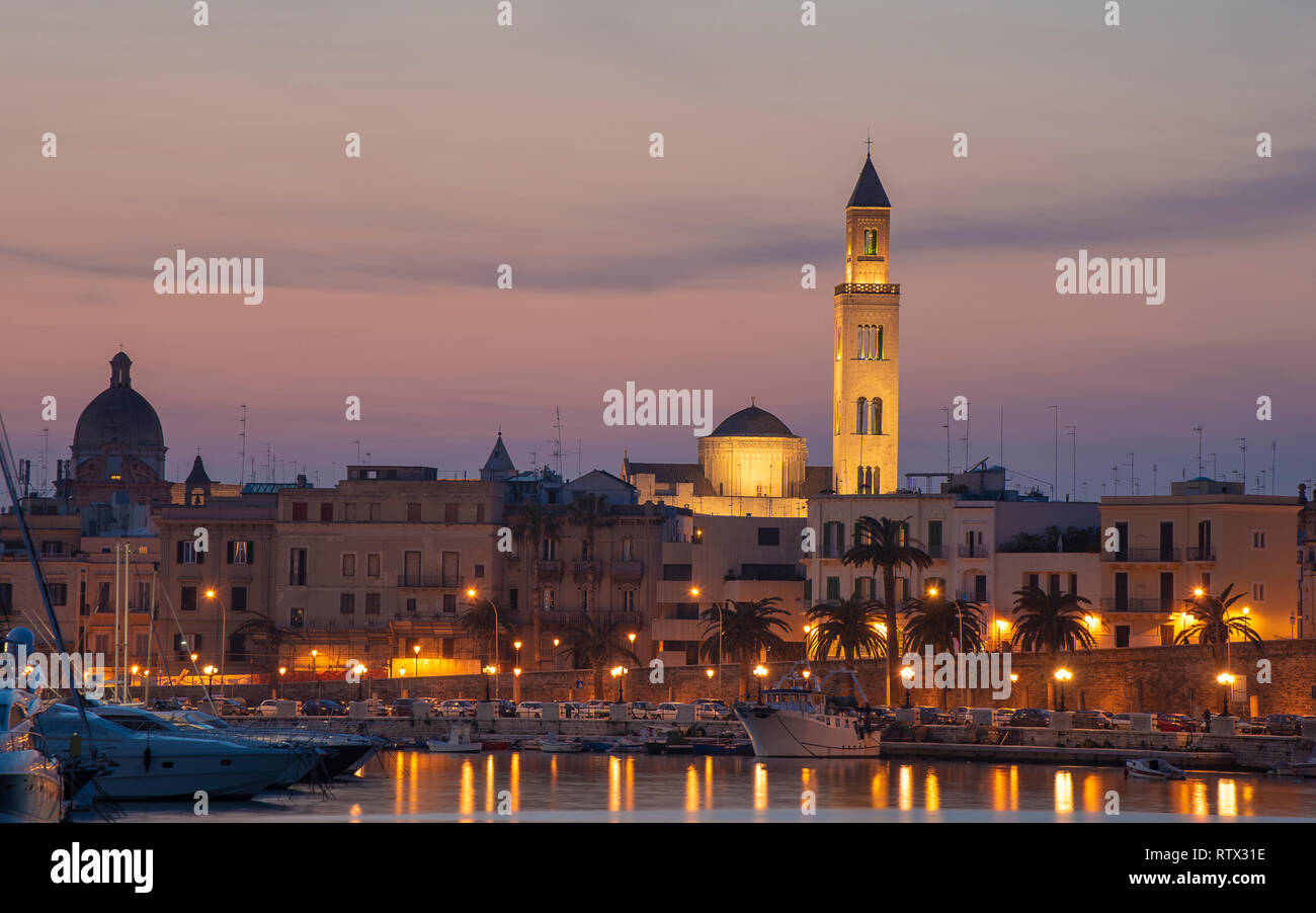 Cityscape of Bari at sunset with Basilica of San Nicola and Romanesque Cathedral. Bari, Puglia, Italy. seafront city view from marina at night. Apulia Stock Photo