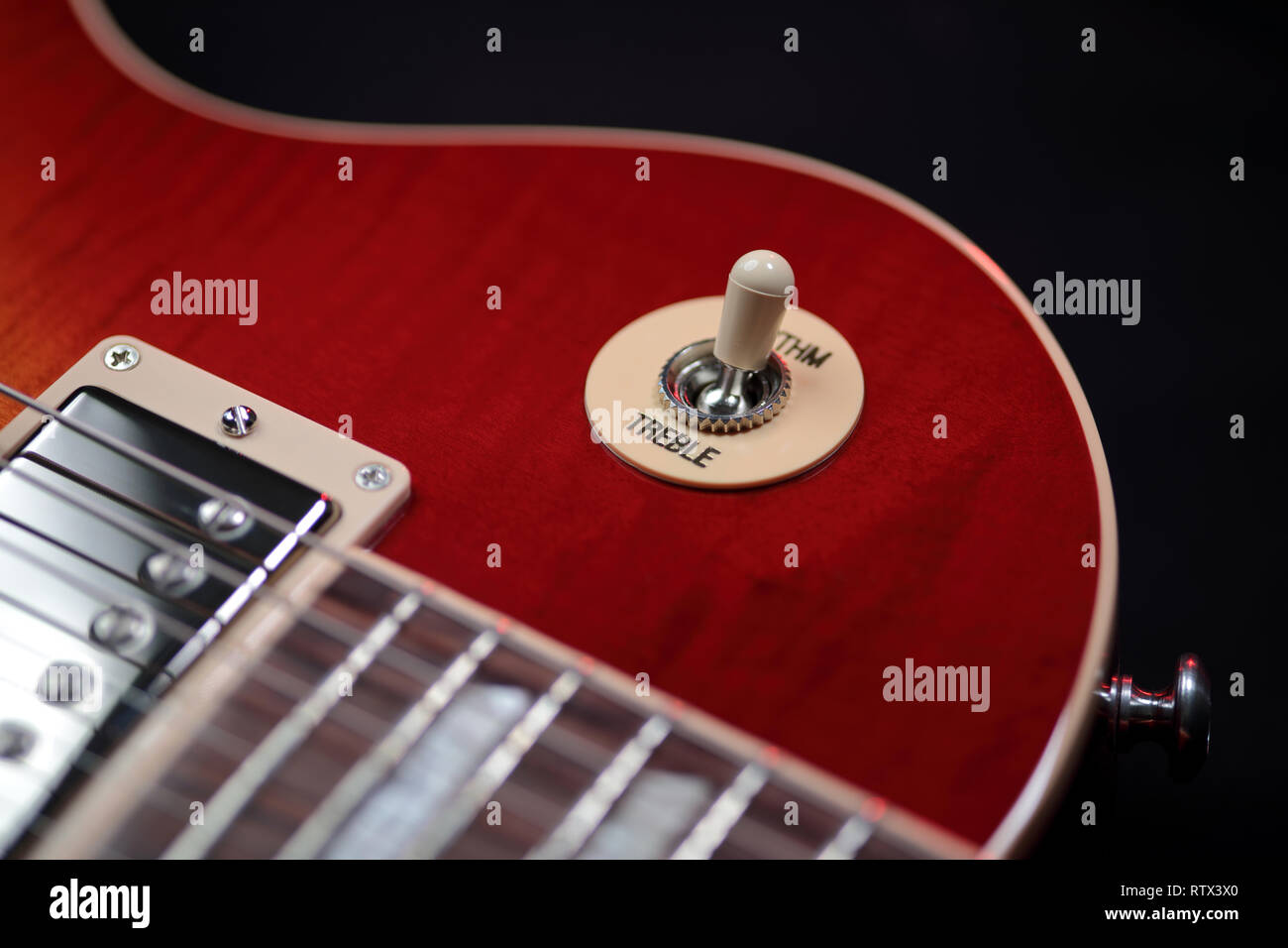 Extreme close up shot of the rhythm and treble switch on a cherry red electric guitar Stock Photo