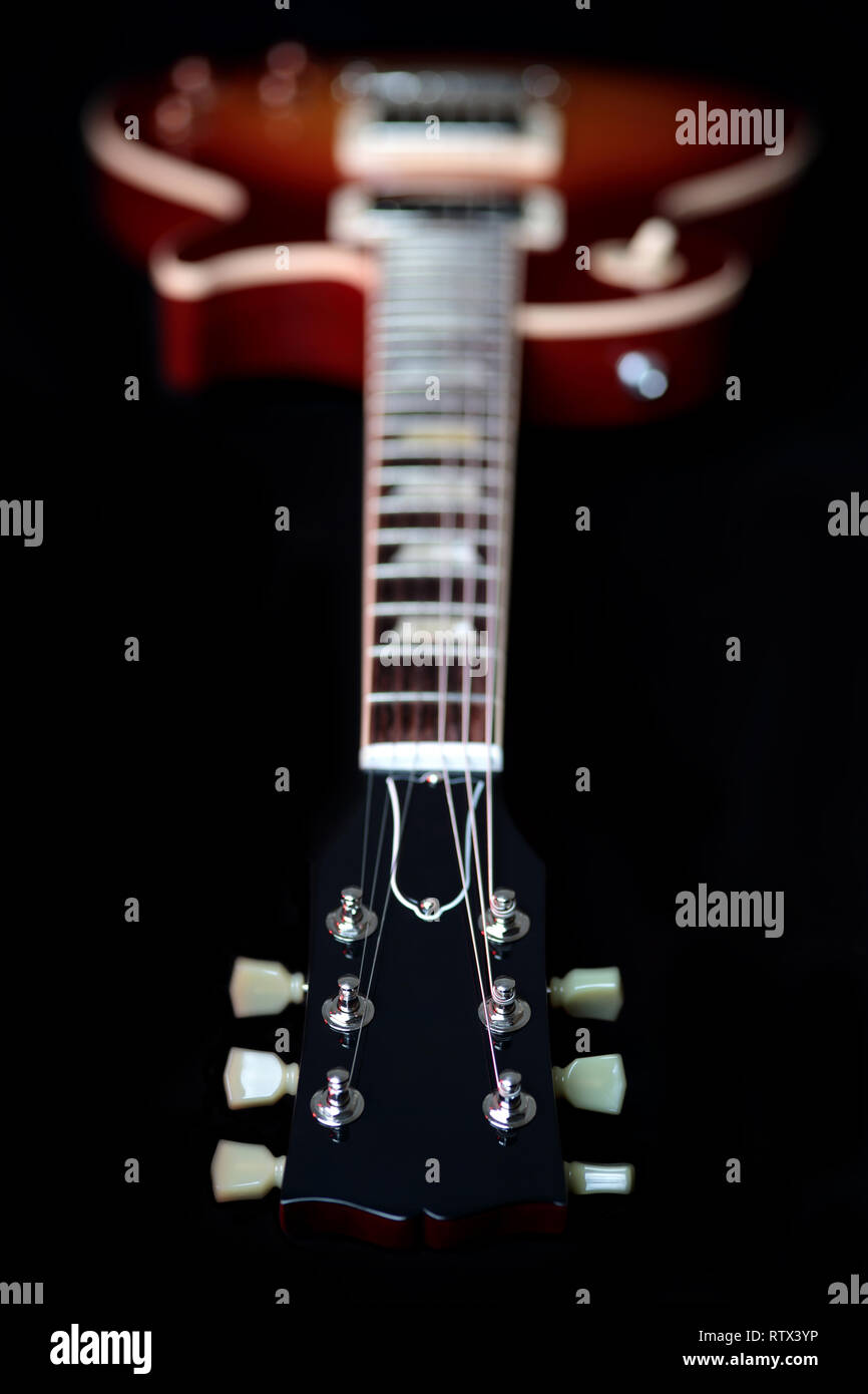 Headstock, machine head tuners and body of a new cherry red Gibson Les Paul Traditional electric guitar. The headstock is in focus and body is blurred Stock Photo