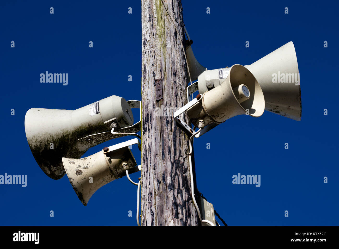 PA public address system speakers fixed to timber telegraph pole Stock
