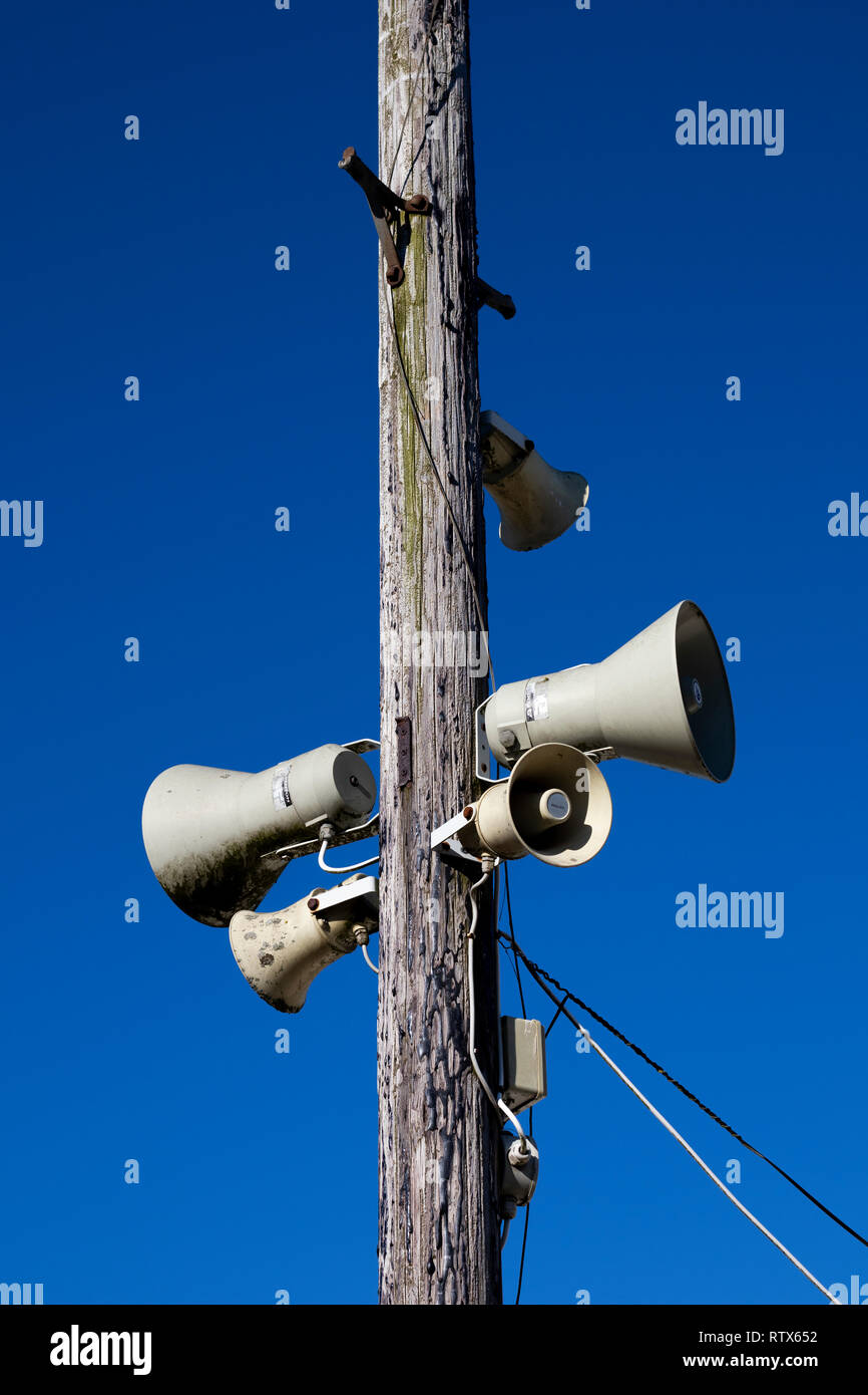 PA public address system speakers fixed to timber telegraph pole Stock