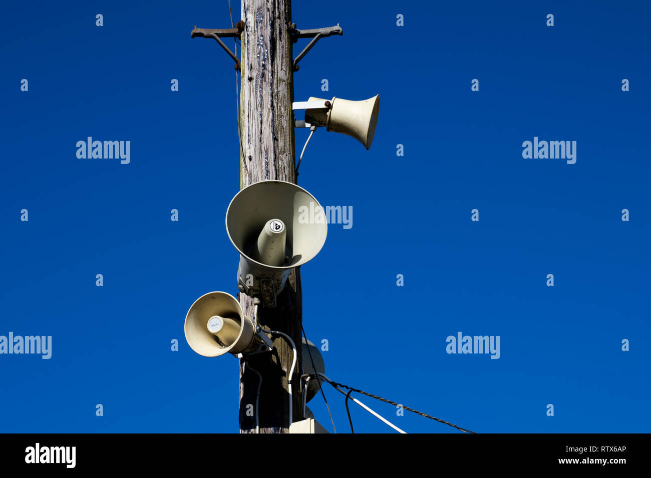 PA public address system speakers fixed to timber telegraph pole Stock