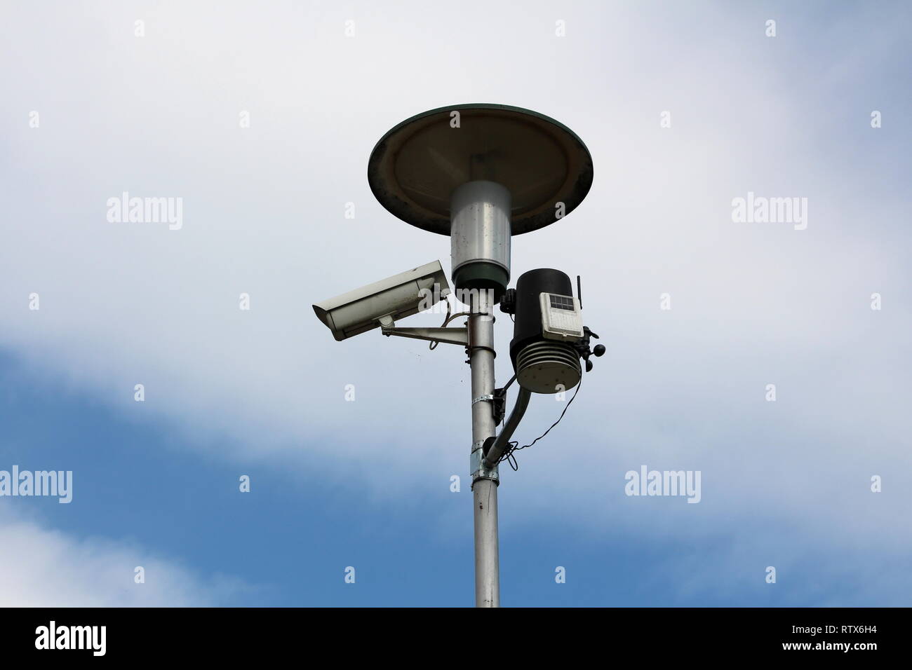 Tall street light on metal post with mounted surveillance camera and ...
