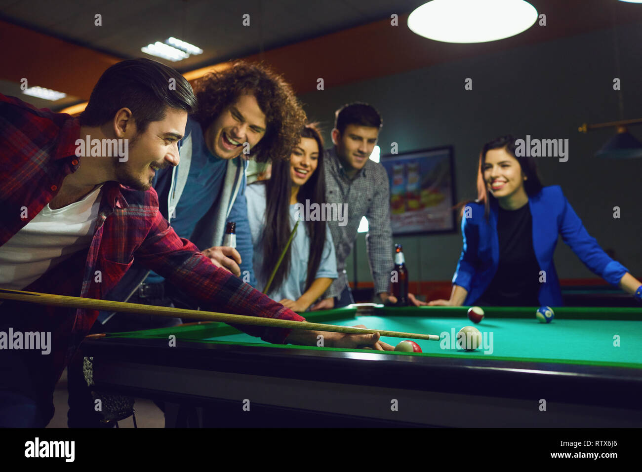 Friends play billiards in bar. Stock Photo
