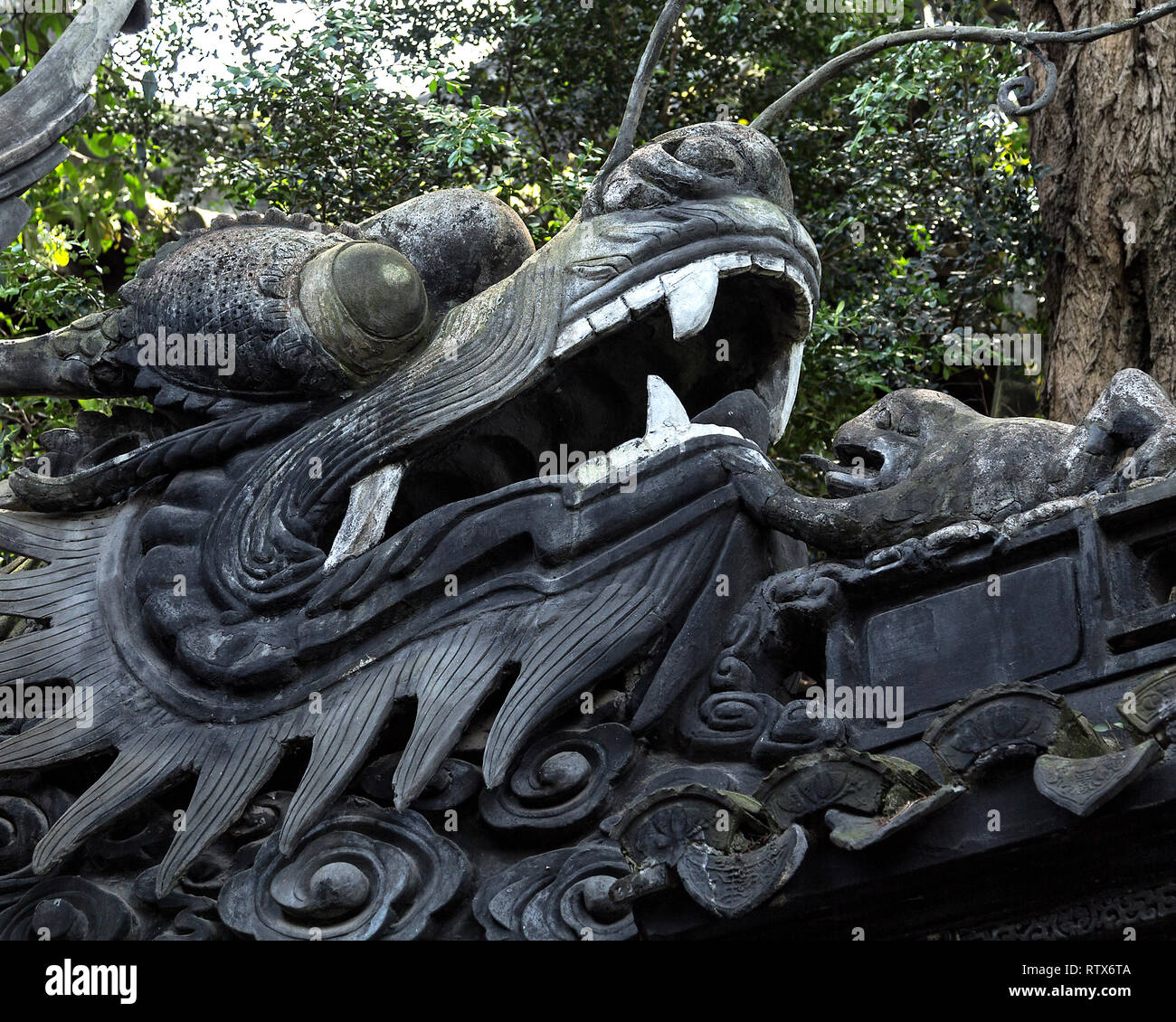 Detail of a dragon wall in Yu Garden, Old Shanghai. The sculpture features a dragon head and a toad representing auspicious power, luck and longevity. Stock Photo