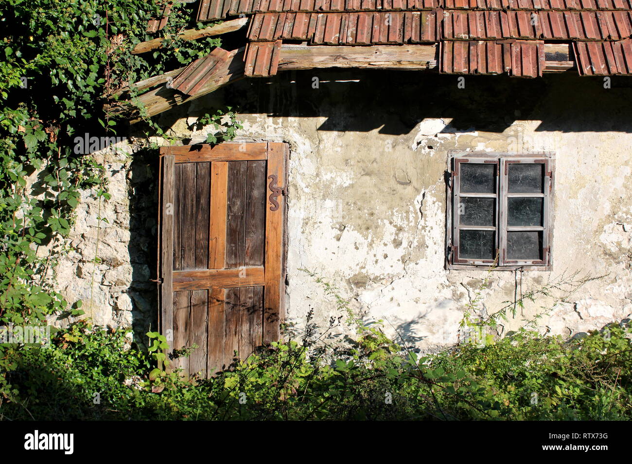 Wooden doors and windows mounted with decorative rusted metal hinges on ...