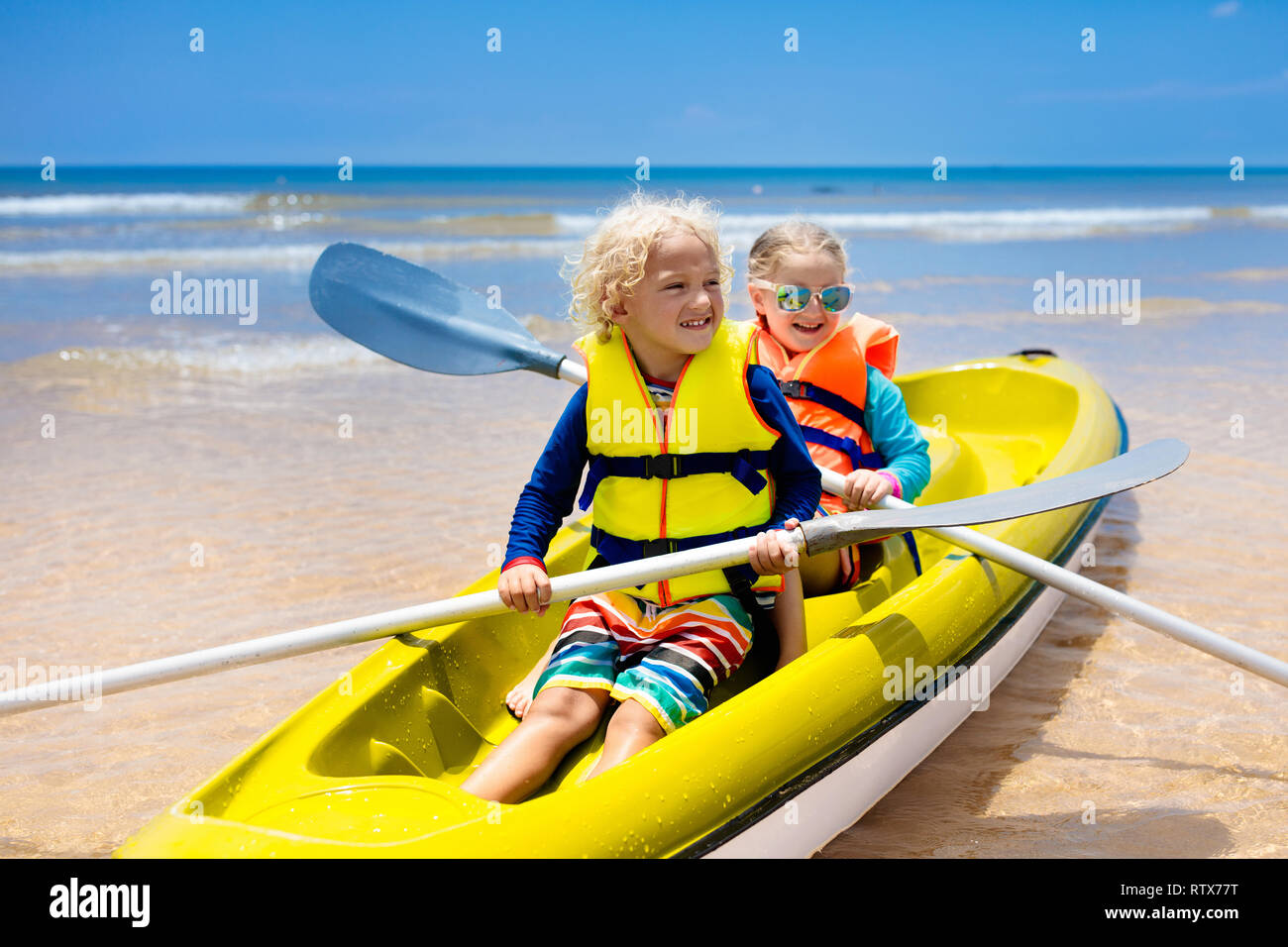 Kids kayaking in ocean. Children in kayak in tropical sea. Active