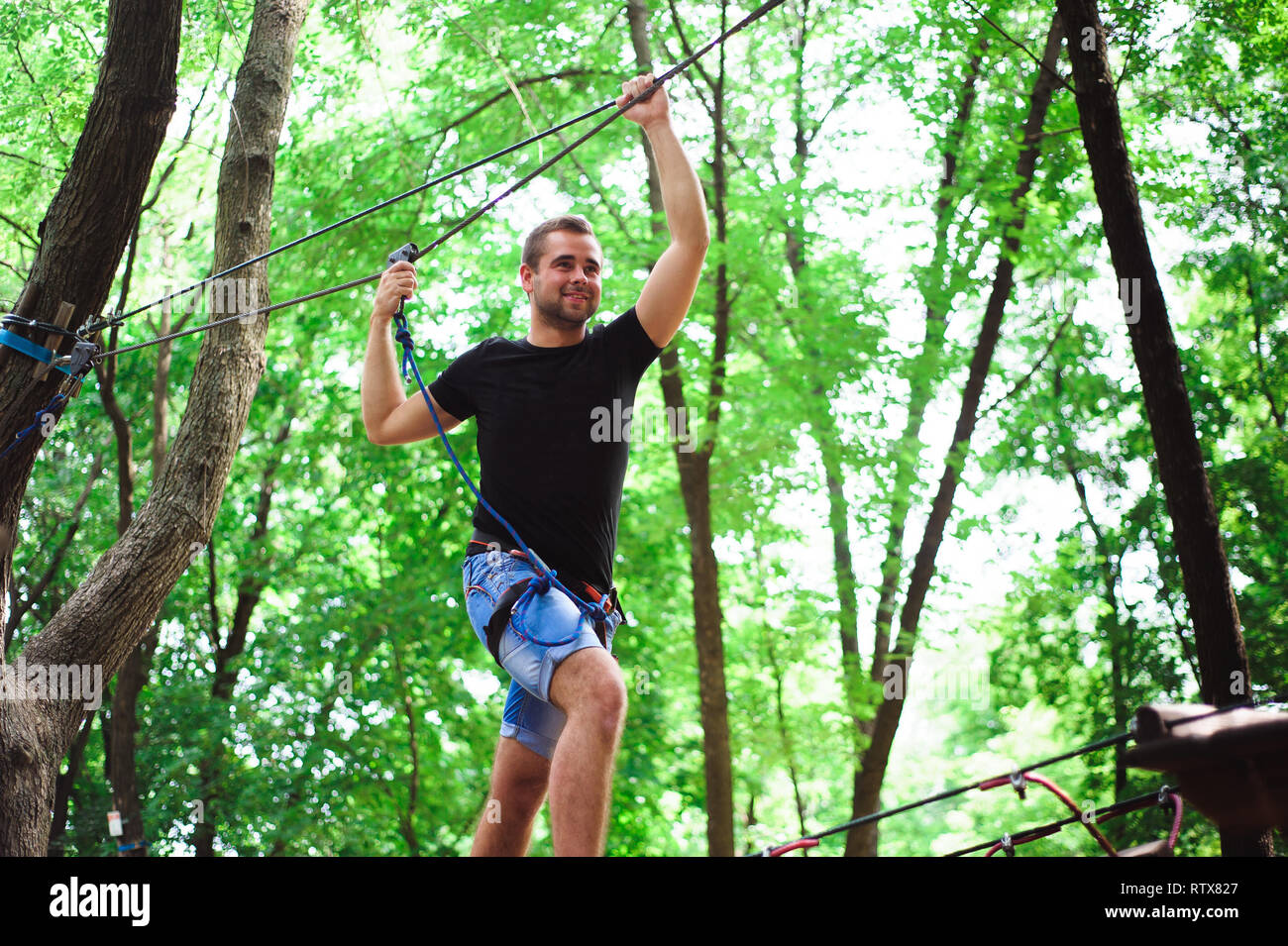 Hiking in the rope park beautiful sports guy Stock Photo Alamy