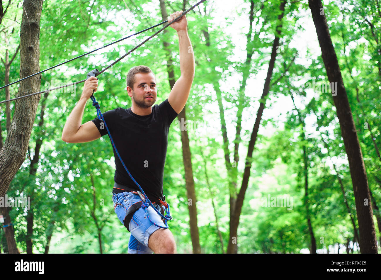 Hiking in the rope park beautiful sports guy Stock Photo Alamy