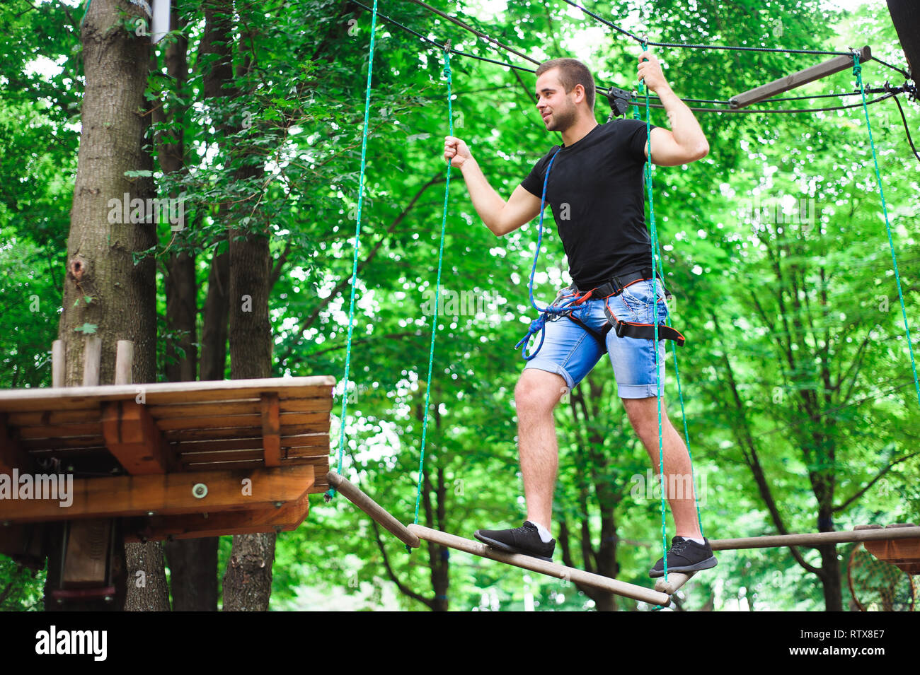 Hiking in the rope park beautiful sports guy Stock Photo Alamy