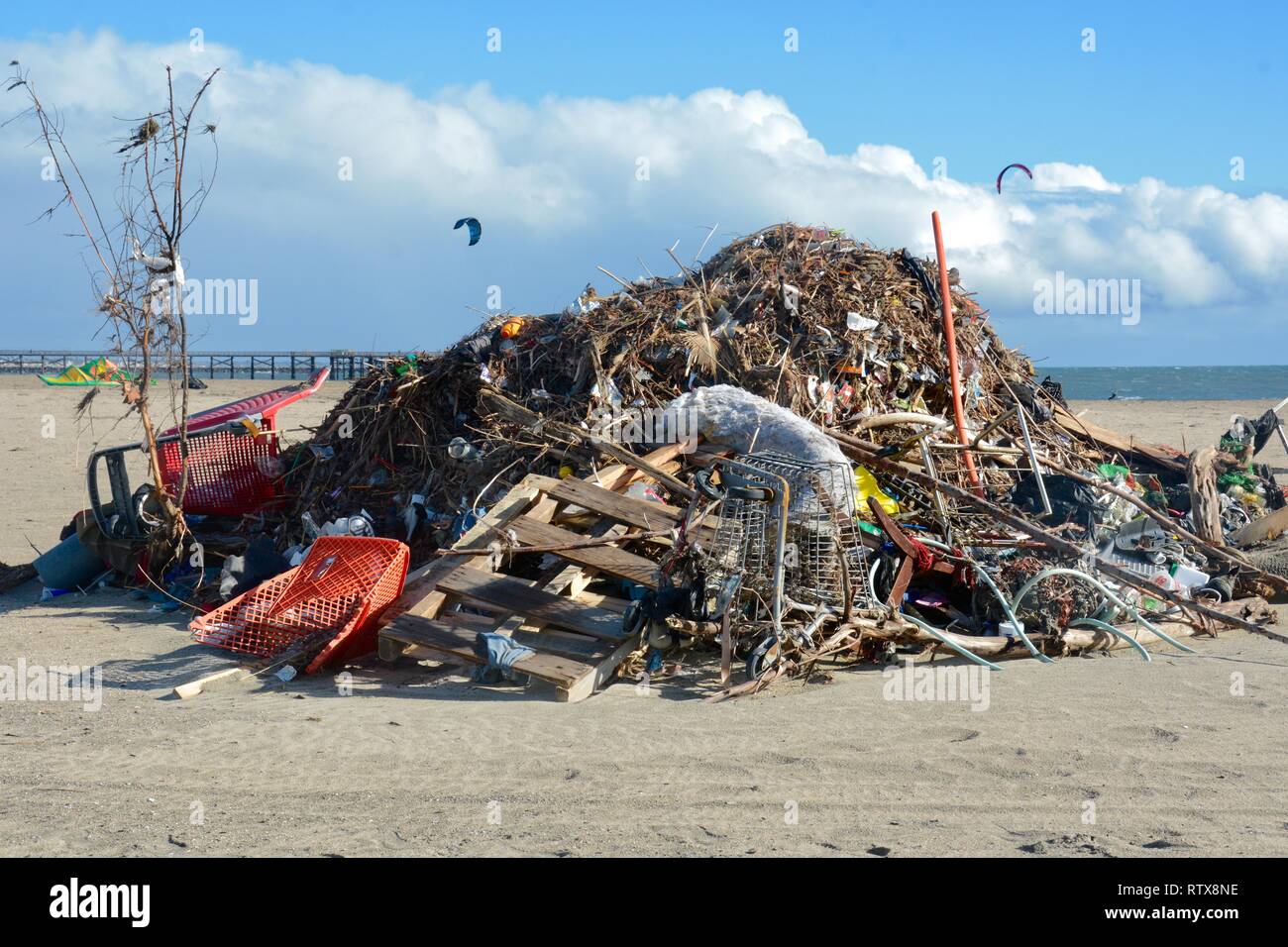 Seal Beach, CA / USA - February 17 2019: Aftermath of storms. Debris includes shopping carts washed up on beach at the mouth of the San Gabriel River. Stock Photo