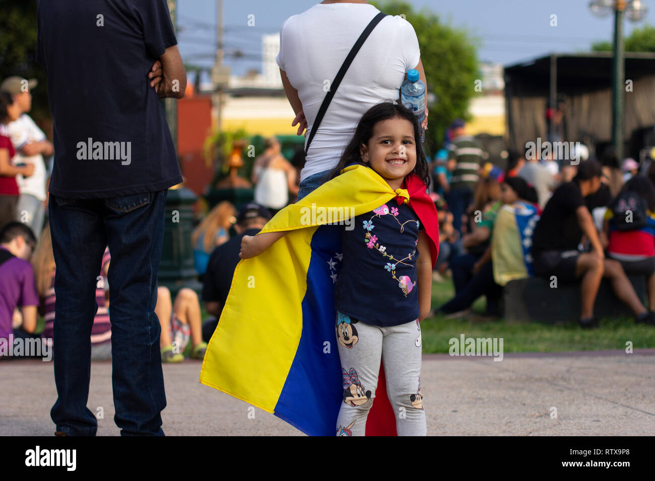 Lima, Peru - February 2 2019: Adorable cute little girl playing with Venezuelan flag at protest against Nicolas Maduro in support of Juan Guaido Stock Photo