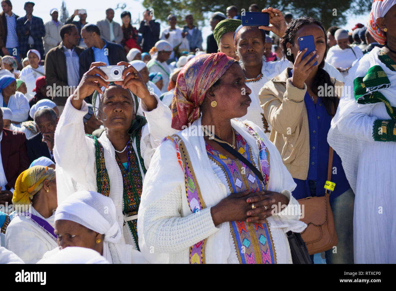 JERUSALEM - NOV 20, 2014: Ethiopian Jewish women mix old tradition of prays, with modern documentation devices, at the Sigd, in Jerusalem, Israel. The Stock Photo