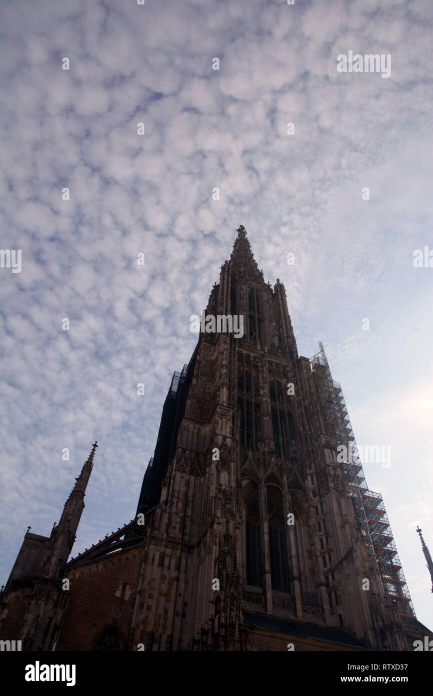 tallest steeple of a church exterior view the minster of ulm overexposed abstract look, Ulm Minster exterior view from the west in front of blue sky c Stock Photo