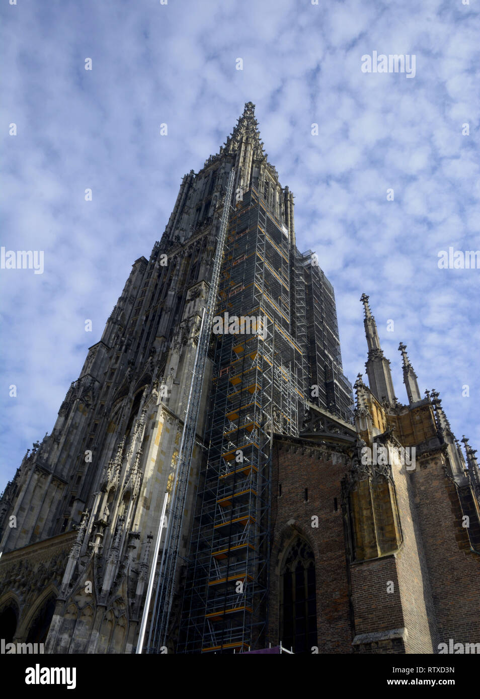 Ulm Minster exterior view from the west in front of blue sky covered with small clouds, tallest church of the world the minster of ulm abstract exteri Stock Photo