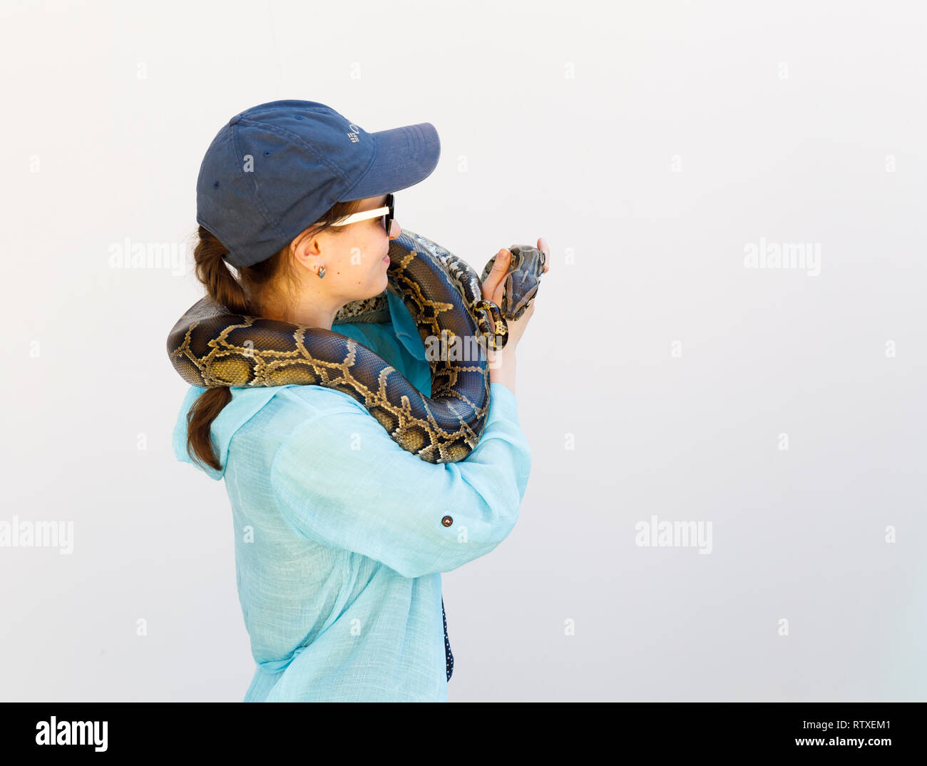 PHU HAI, VIETNAM - FEBRUARY 17, 2018: Tourist hold long exotic snake around neck in Phu Hai, Vietnam Stock Photo
