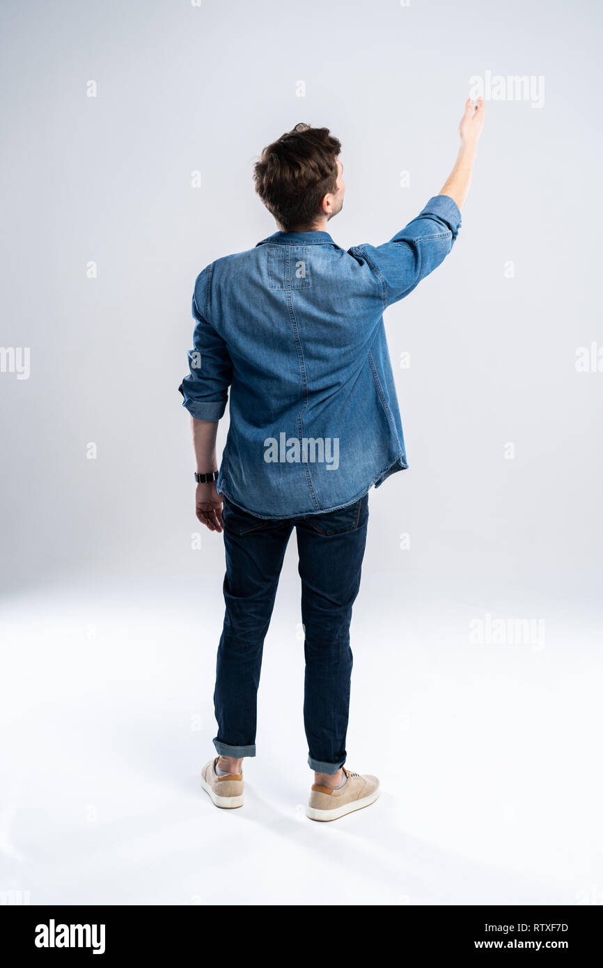back view of a casual man standing on white background. Stock Photo