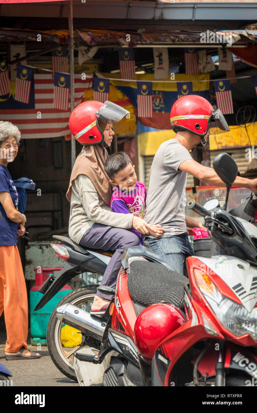 couple riding with small child on scooter in Kuala Lumpur Malaysia Stock Photo