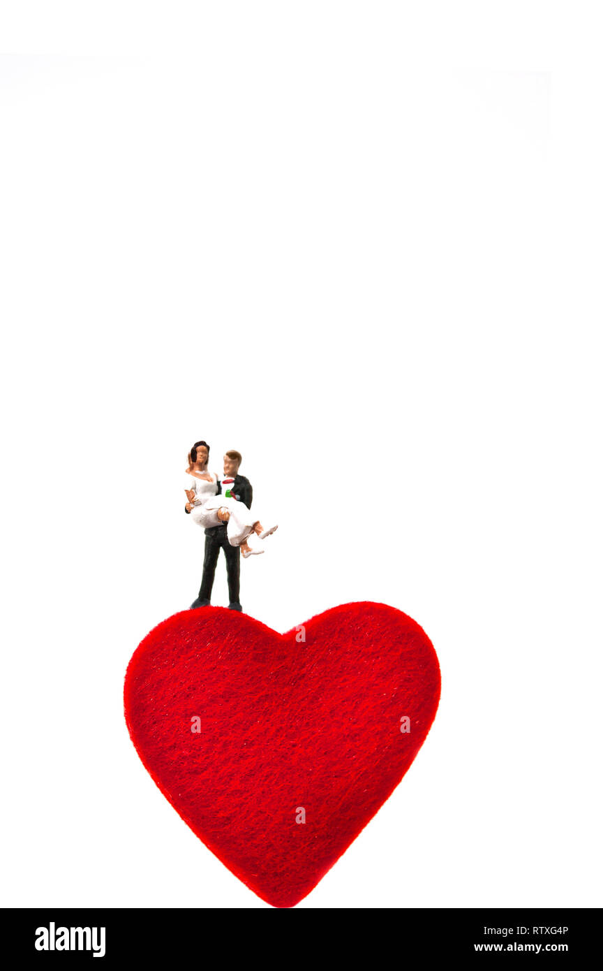 married couple, miniature figurine standing on a heart shape, love and marriage concept Stock Photo