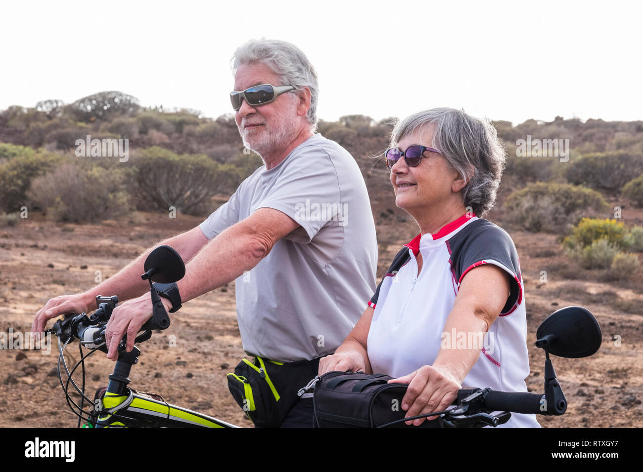 Cheerful caucasian adult senior couple with mountain bike doing healthy