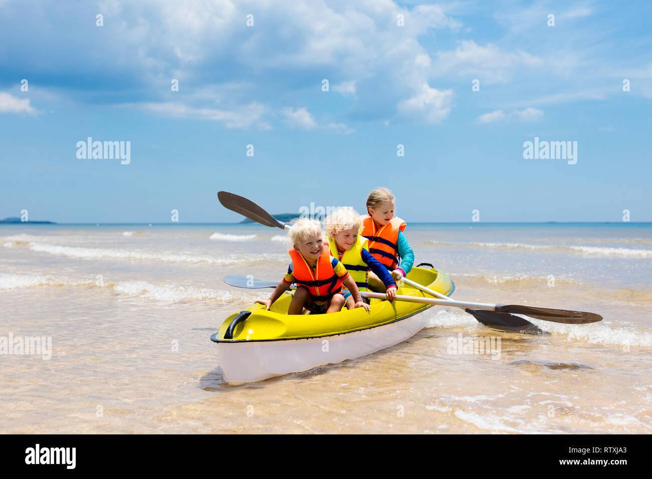 Kids kayaking in ocean. Children in kayak in tropical sea. Active
