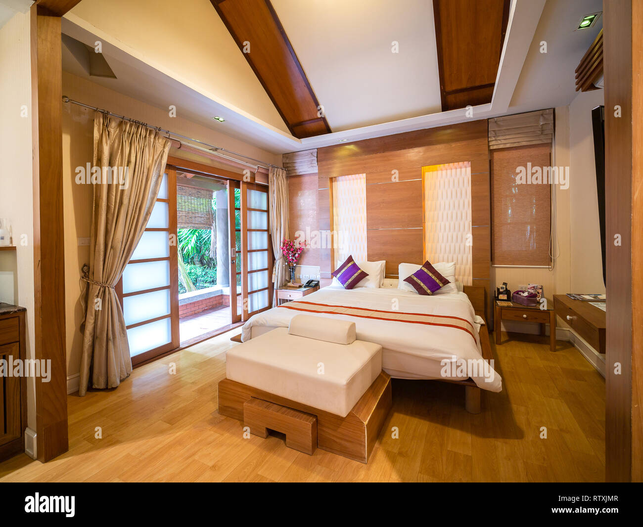 Luxury room with bed in warm light and tree view outside, room of hotel resort in Thailand. Japanese style Stock Photo