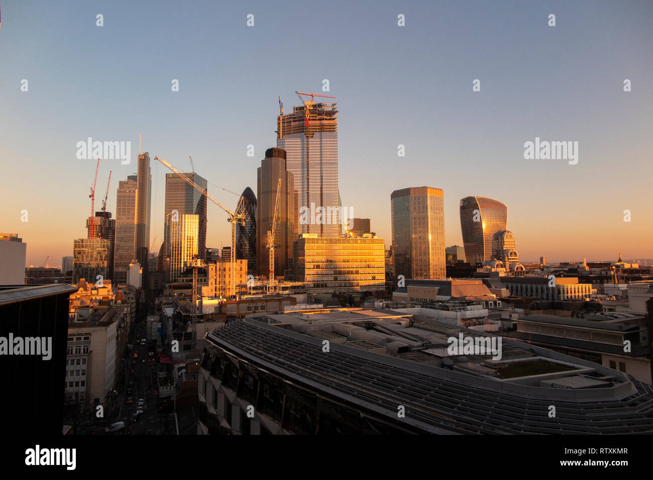 A dramatic City of London skyline with the high rise buildings bathed in golden light Stock Photo