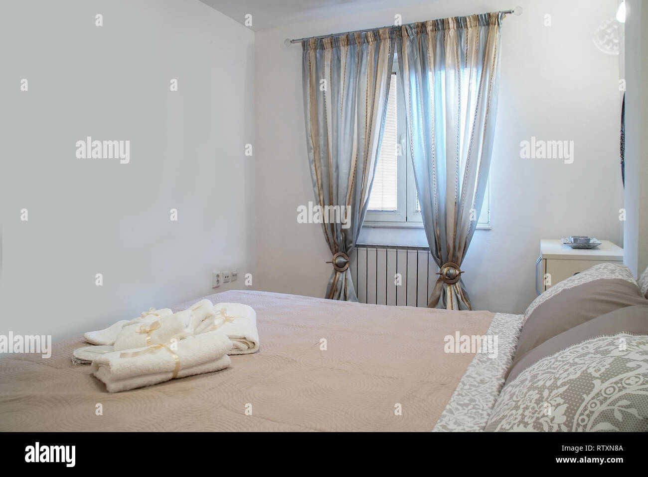 Brown Pillow On Brown Bed In Bright Bedroom With Silver Curtains