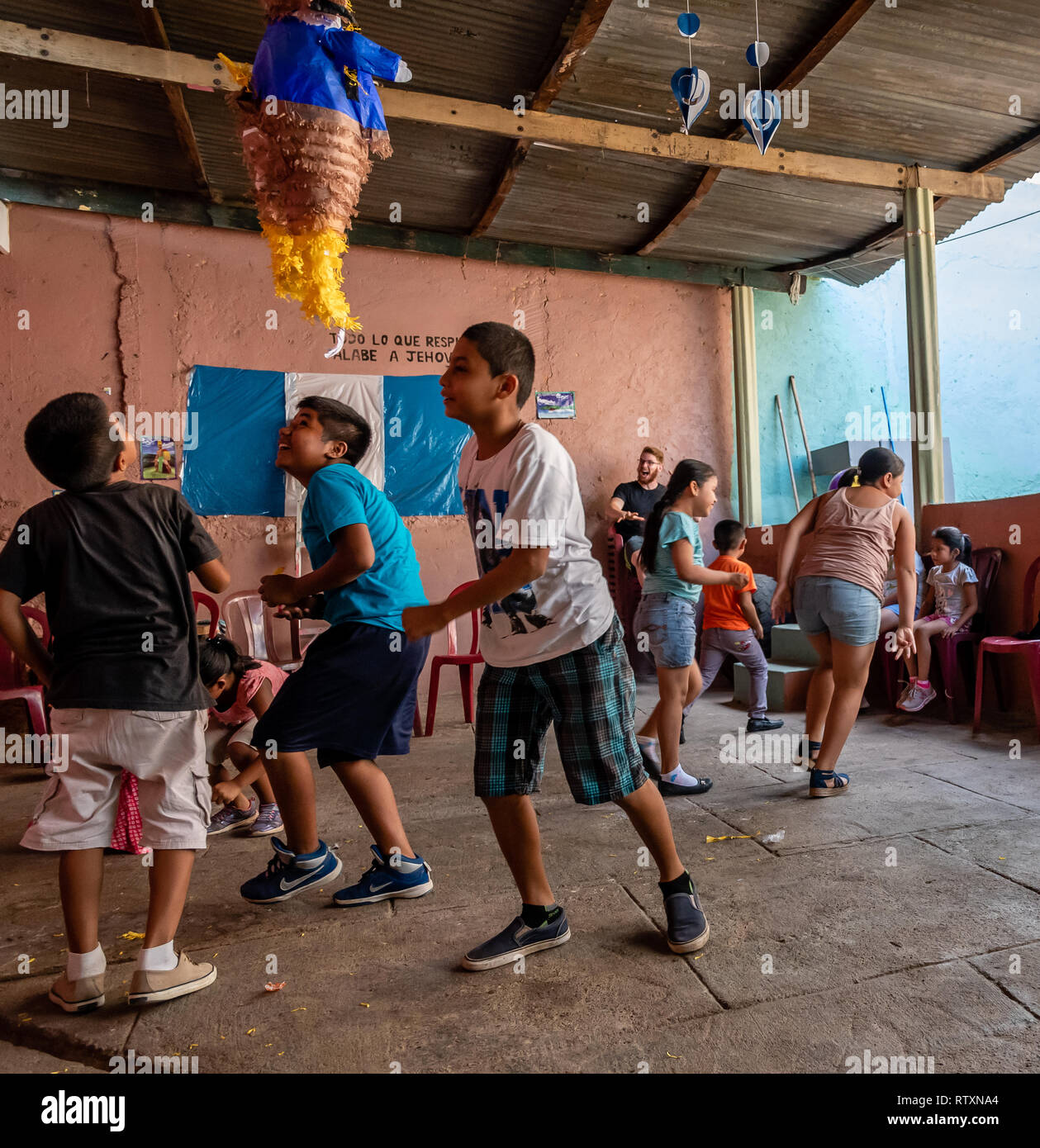 Latin bambini alla festa di compleanno in esecuzione dopo la caramella al  di fuori di un'pinata in Guatemala Foto stock - Alamy