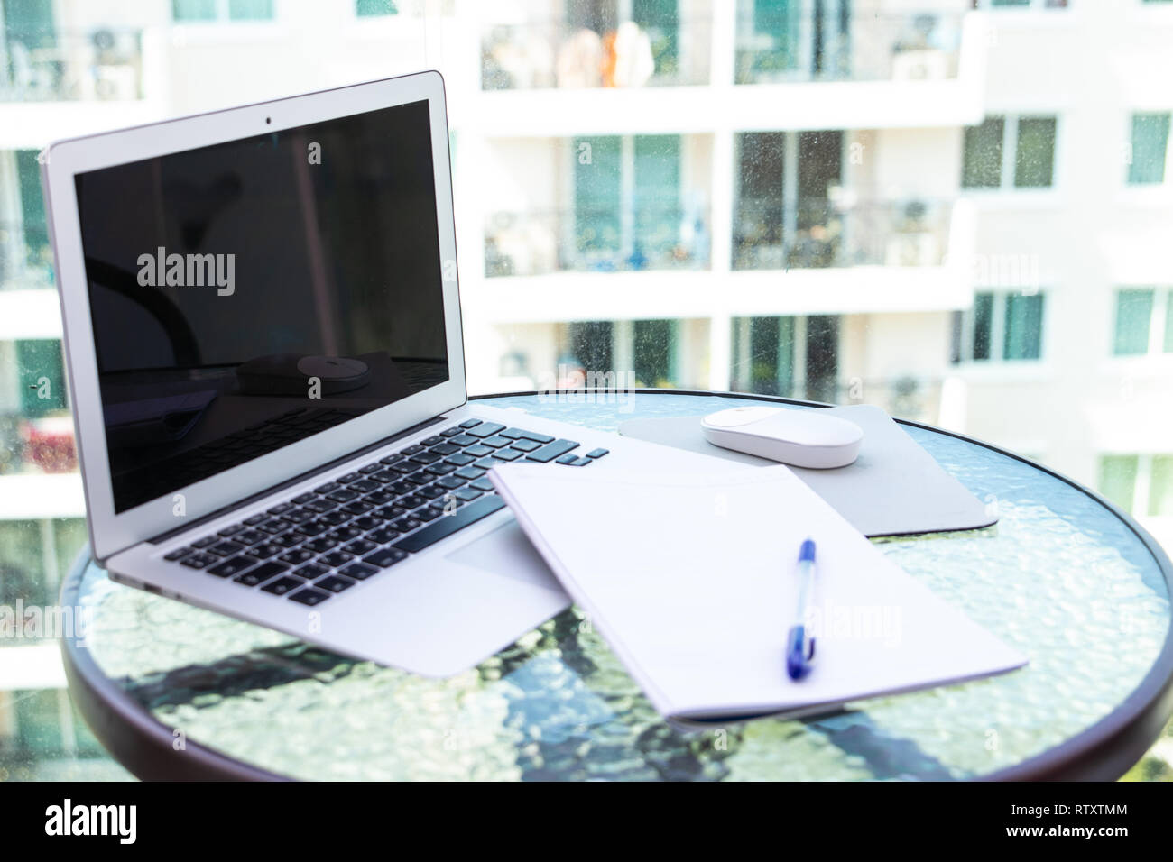 Work office desk with a computer laptop, notebook, pen on the glass table. Stock Photo