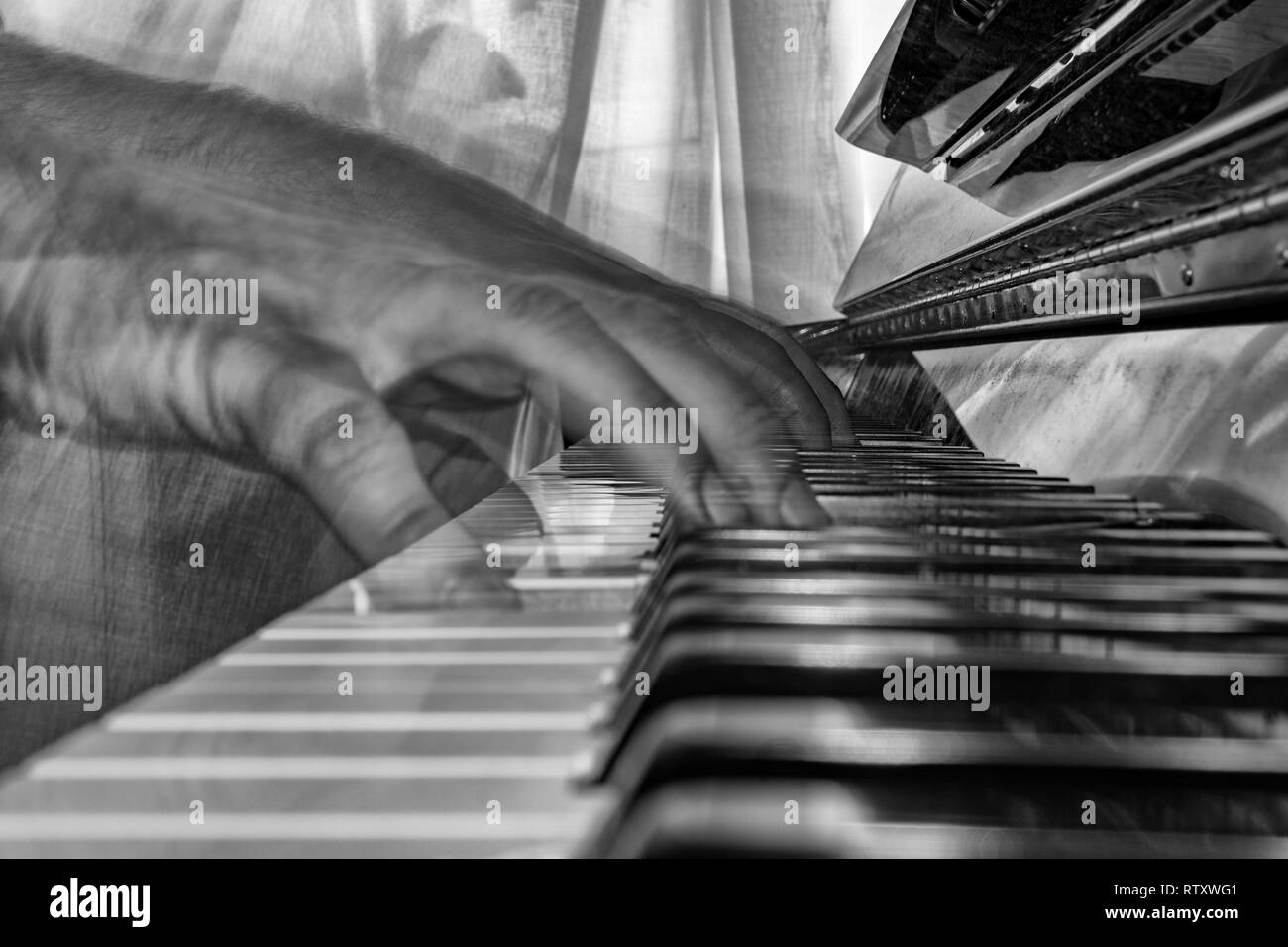 Hands playing piano while moving move effect b&w Stock Photo - Alamy