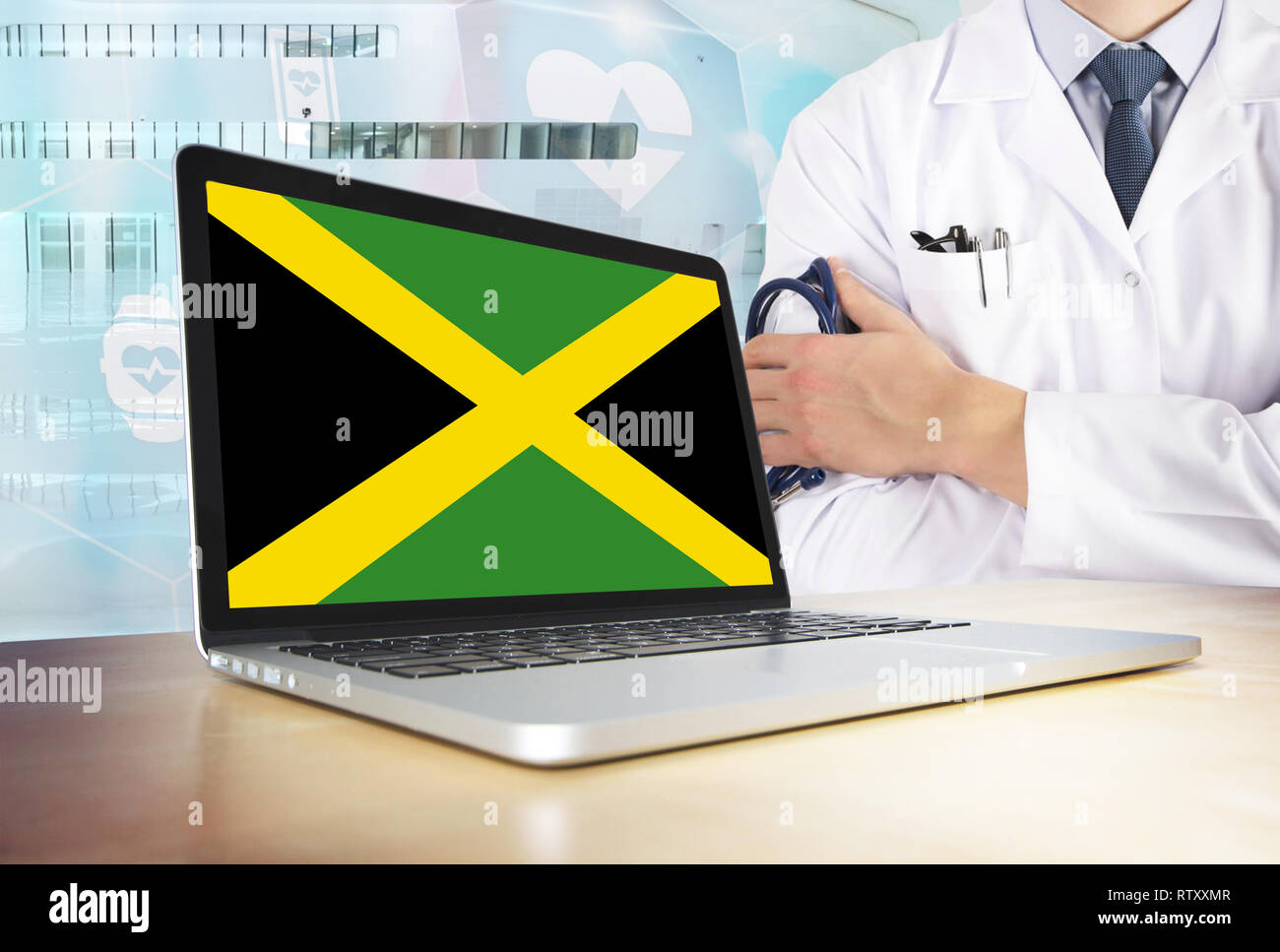 Jamaica healthcare system in tech theme. Jamaican flag on computer screen.  Doctor standing with stethoscope in hospital. Cryptocurrency and Blockchain  Stock Photo - Alamy