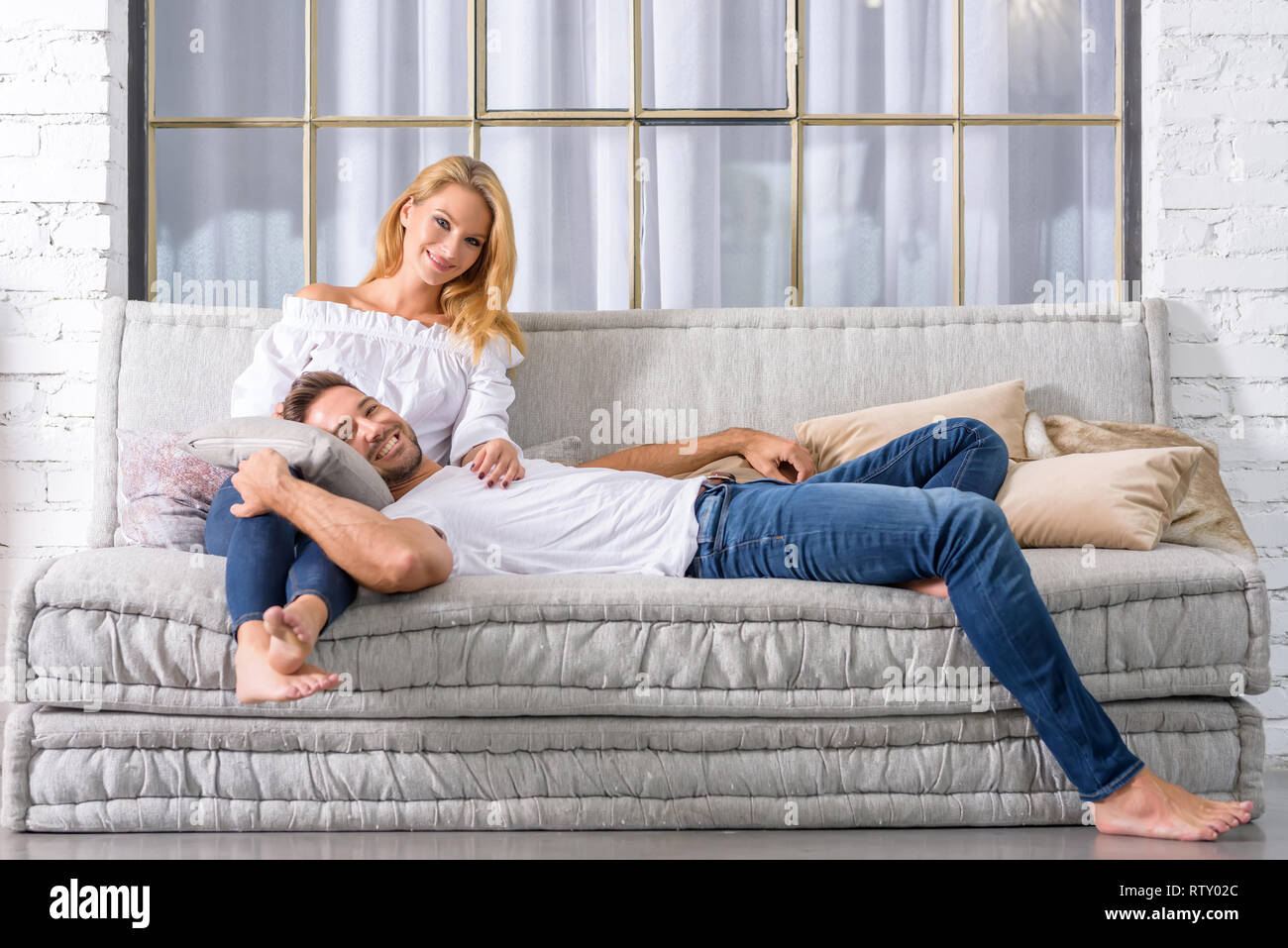 philosopher Minister Affectionate A handsome young man lying on the sofa with head on his girlfriends chest  Stock Photo - Alamy