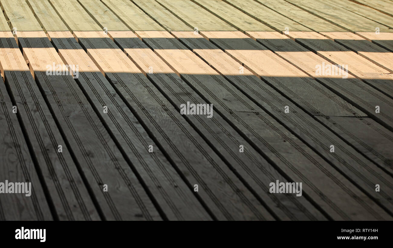 Regular exterior wooden board floor, sun casting shadow from side. Stock Photo