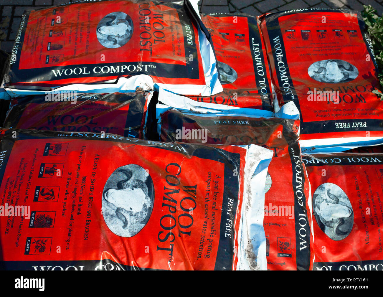 A stack of bags of peat free wool and bracken compost for sale in a