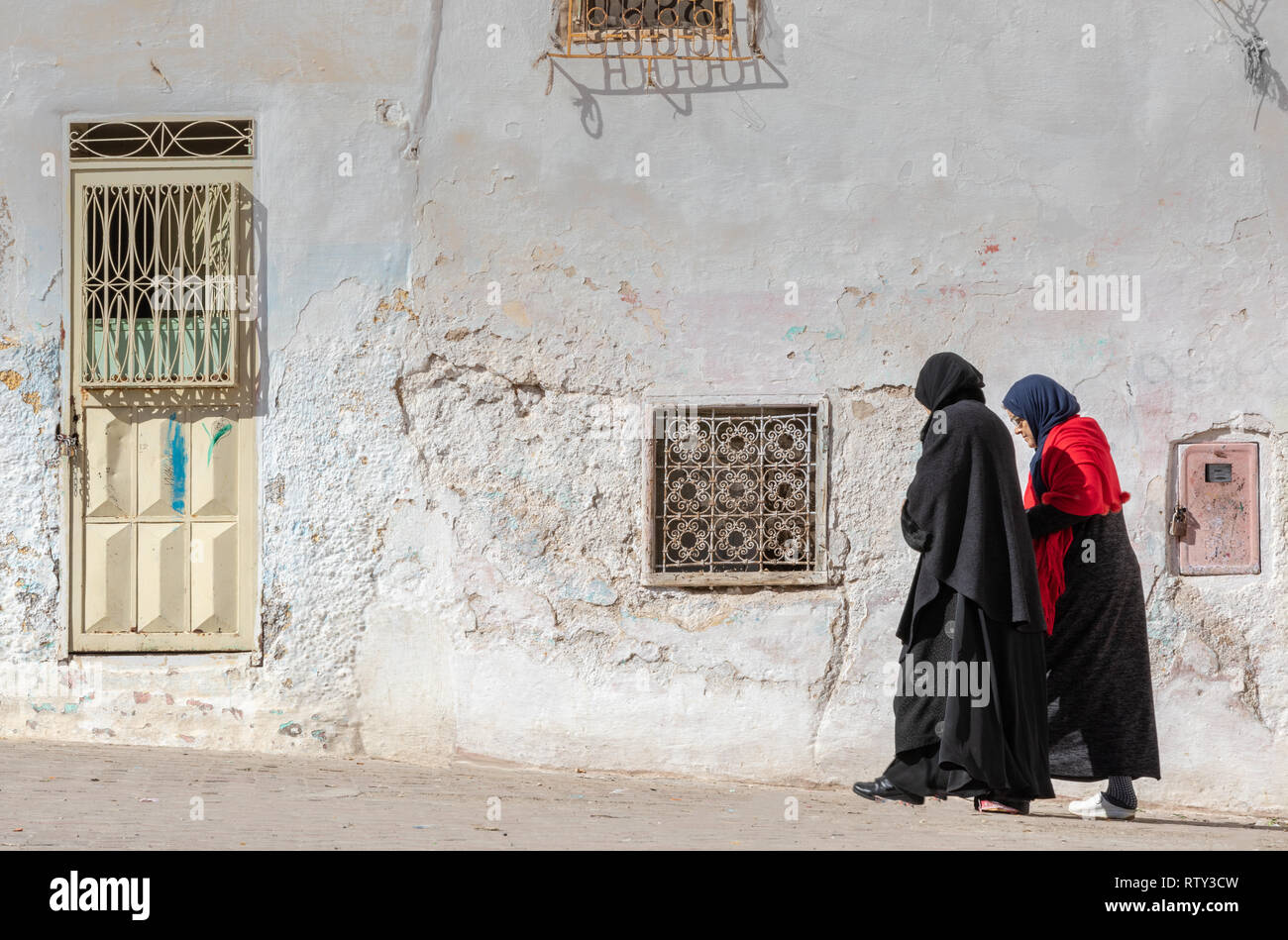 Two muslim woment walking in the ruins of the ancient Jewish Quarter (mellah) in Sefrou, Morocco Stock Photo