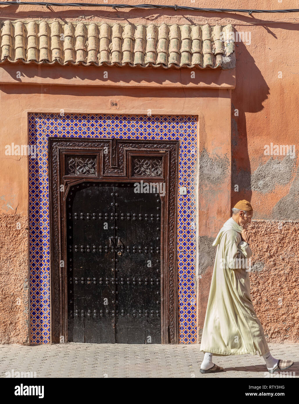 Elderly man in djellaba walking in the kasbah, Marrakesh Stock Photo