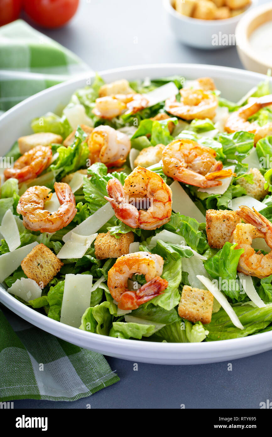 Homemade caesar salad with shrimp and dressing on the side Stock Photo