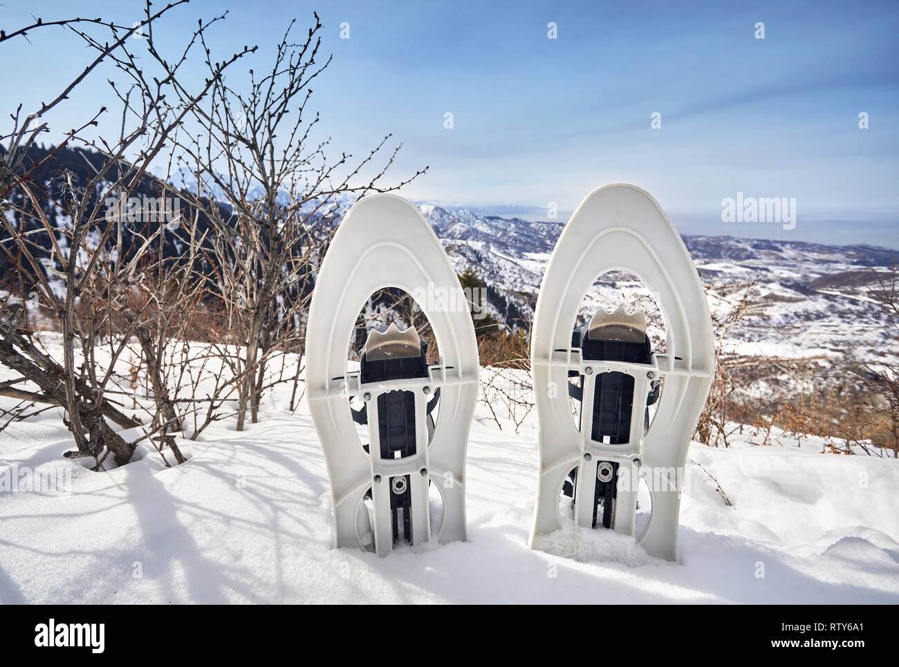Snowshoes in the snow on the mountain peak against blue sky Stock Photo