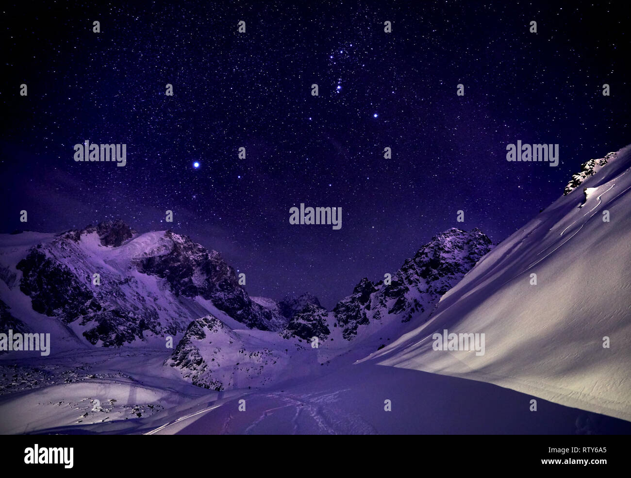 Beautiful winter landscape of the snowy mountains against starry night sky Stock Photo