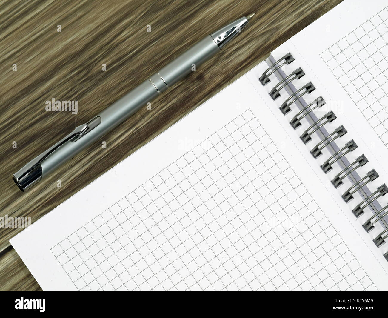 close up of blank notebook and a pen on wooden office desk with copy space Stock Photo