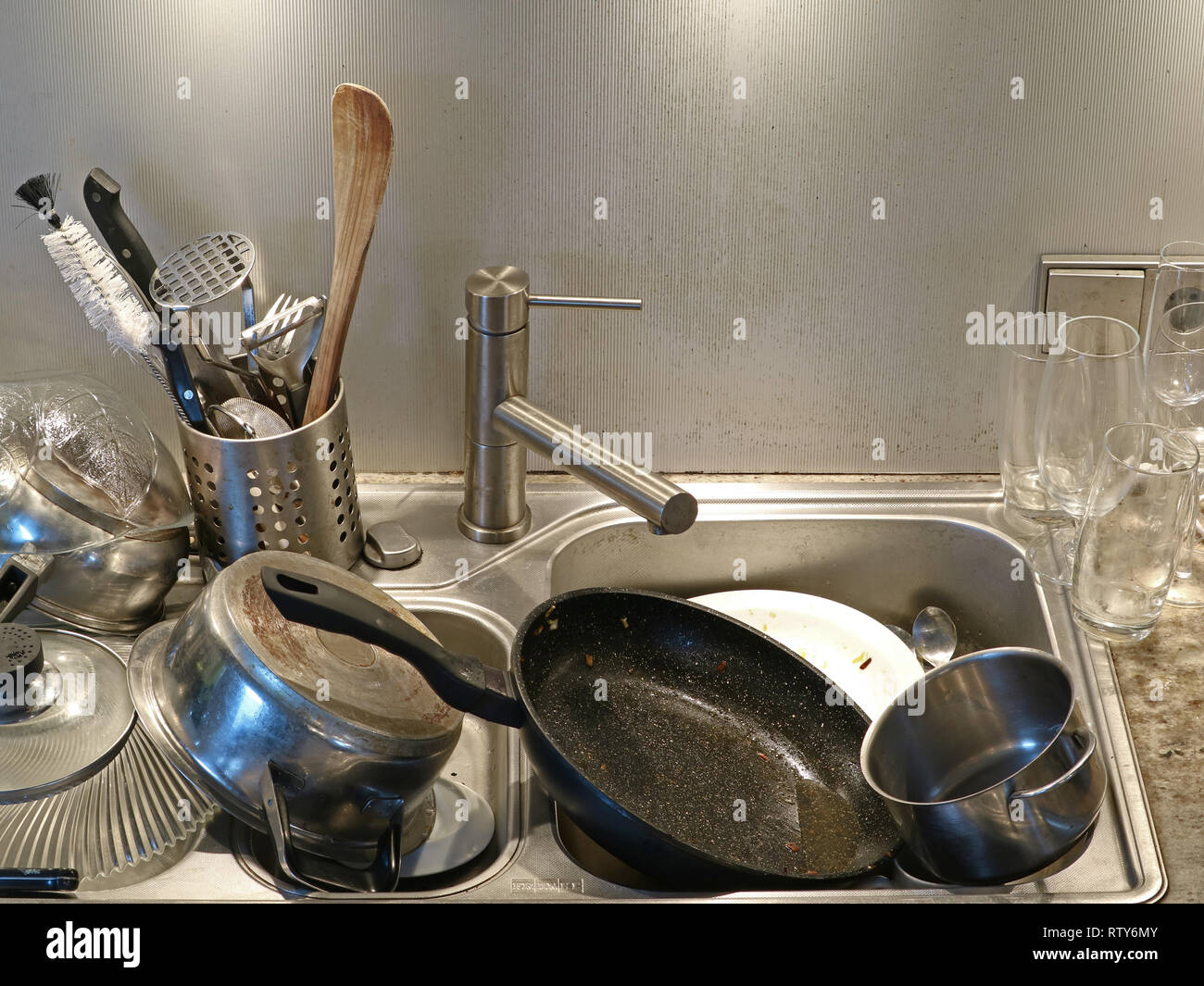 Heap of dirty utensils in the sink, close up of dirty kitchen Stock Photo