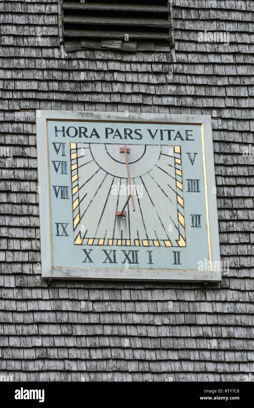 Sundial on the shingled spire of St Michael and All Angels Church in Thursley, Surrey, UK, with the latin phrase Hora Pars Vitae Stock Photo